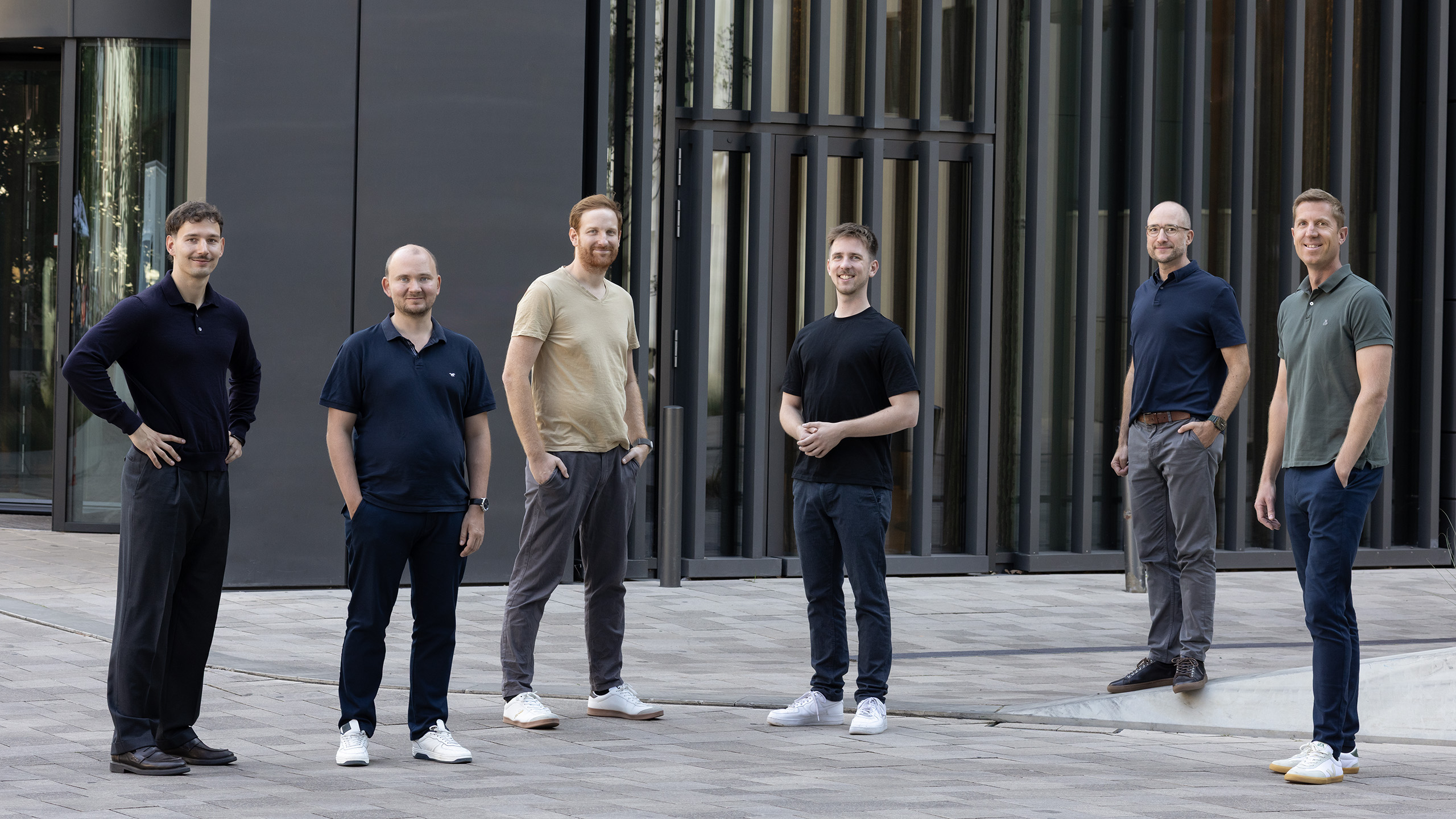 Teamfoto: Sechs Männer des Investment-Teams "Venture-Capital" vor einem modernen, dunklen Bürogebäude.