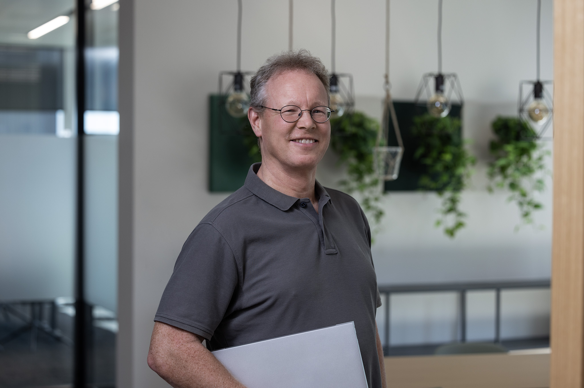 Teammitglied des Investitionsbereichs „Kleine Unternehmen“: Ein lächelnder Mann in einem modernen Büro.