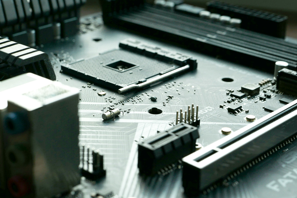 Nahaufnahme einer Leiterplatte mit verschiedenen elektronischen Bauteilen, Steckverbindungen und einem Prozessorsockel.